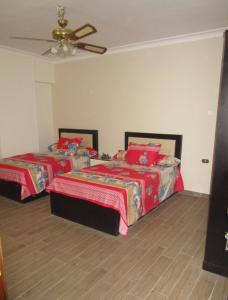 sypialnia z 2 łóżkami i wentylatorem sufitowym w obiekcie Luxury Furnished Apartment w Kairze