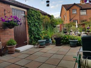 a garden with a bunch of potted plants on a patio at CEAD MILE FAILTE WEST BELFAST in Belfast