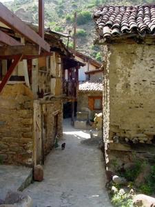 
a narrow alleyway leads to a stone building at The Mill Hotel in Kakopetria
