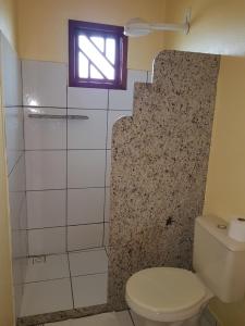uma casa de banho com um WC e uma janela em Pousada Estância da Barra em Conceição da Barra