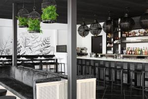 a restaurant with a bar with chairs and pendant lights at The Menhaden Hotel in Greenport