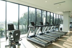 a row of treadmills in a gym with windows at QUARTZ HOTEL & SPA in Tijuana