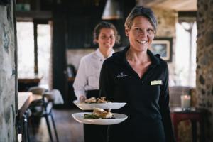 Eine Frau, die mit einem Mann einen Teller Essen hält. in der Unterkunft Mahu Whenua in Wanaka