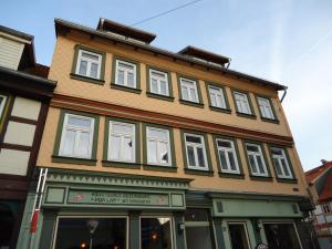 ein hohes Gebäude mit weißen Fenstern auf einer Straße in der Unterkunft Pension an der Stadtmauer Apartments in Wernigerode