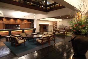 a lobby with tables and chairs in a restaurant at Kurashiki Kokusai Hotel in Kurashiki