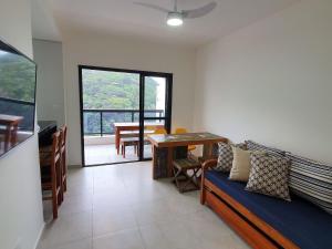 ein Wohnzimmer mit einem Sofa und einem Tisch in der Unterkunft Flats Capitania Varam Pitangueiras in Guarujá