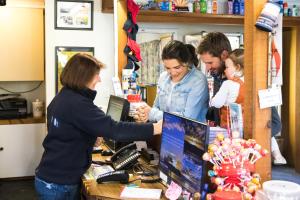 a woman standing at a counter in a store with a customer at Lake Fyans Holiday Park in Lake Fyans