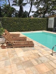 a pair of lounge chairs next to a swimming pool at Santa Cecília Pousada in Guarujá