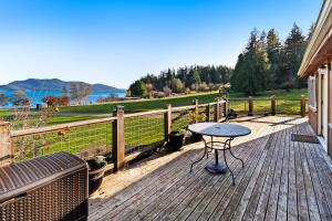 a table on a deck with a view of the water at Obstruction Pass Cottage in Olga