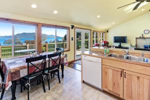 a kitchen with a table and a view of the ocean at Obstruction Pass Cottage in Olga