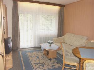 a living room with a couch and a table at Hotel Park Eden in Bad Bellingen