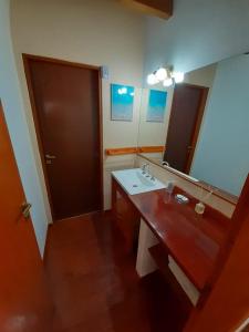 a bathroom with a sink and a mirror at Cabañas Paseo de las Luces in Mar de las Pampas +52 photos