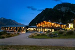 a hotel with a building with mountains in the background at Mt Cook Lodge and Motels in Mount Cook Village