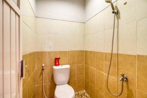 a bathroom with a toilet and a shower at RedDoorz near Condongcatur Bus Station in Yogyakarta +10 photos