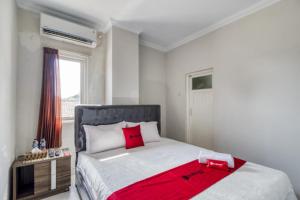 a bedroom with a large bed with a red blanket on it at RedDoorz near Condongcatur Bus Station in Yogyakarta