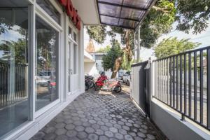 a porch of a house with a motorcycle parked on the street at RedDoorz near Condongcatur Bus Station in Yogyakarta