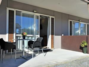 a balcony with a table and chairs in a house at Mohua Motels in Takaka