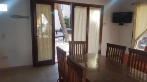 a dining room with a table and chairs and a television at Cabañas Paseo de las Luces in Mar de las Pampas