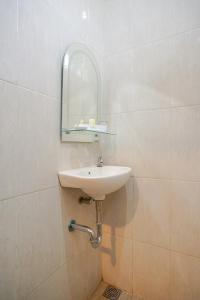 een badkamer met een wastafel en een spiegel aan de muur bij Selaras Inn Syariah in Yogyakarta