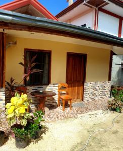 ein Haus mit einem Tisch und einer Bank davor in der Unterkunft Indino Guesthouse in Moalboal