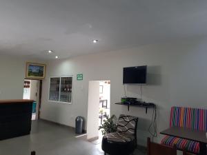a waiting room with a chair and a tv on the wall at Xplora Hostel Cusco in Cusco