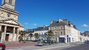 a city street with a bus stop in front of a building at Appart Titanic Cherbourg Centre Port in Cherbourg en Cotentin