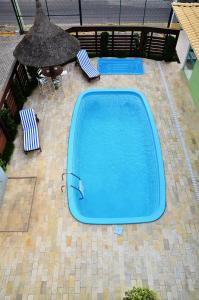 uma piscina vazia com duas cadeiras e um guarda-sol em Pousada Mar Do Leste em Florianópolis