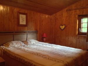 um quarto com uma cama grande numa parede de madeira em Quinta Do Circo - Serra Da Estrela - Turismo Rural em Cortes do Meio
