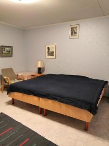 a bedroom with a bed with a black blanket on it at Homestay cozy hosting in Tervakoski