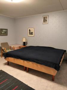 a bedroom with a bed with a black blanket on it at Homestay cozy hosting in Tervakoski