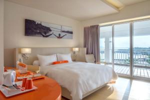 a hotel room with a large bed and a large window at HARRIS Resort Barelang Batam in Sagulung +27 photos
