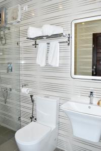 a bathroom with a toilet and a sink and a mirror at J7 Villaj Resort in Trincomalee