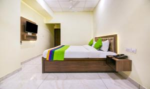 a bedroom with a bed and a tv on a wall at Itsy by Treebo - Oasis Inn in Jalandhar
