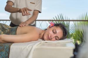 Eine Frau bekommt eine Massage in einem Spa in der Unterkunft HARRIS Resort Barelang Batam in Sagulung