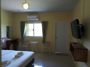 1 dormitorio con 1 cama, TV y ventana en Bangtao Mango House, en Bang Tao Beach