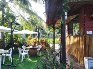 a patio of a house with a table and chairs at Pink Kangaroo Bungalows in Ko Kood