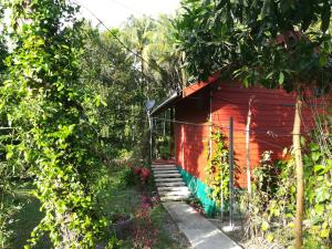 a red house with graffiti on it in a garden at Pink Kangaroo Bungalows in Ko Kood