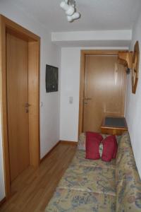 a small bedroom with a bed with red pillows at Appartment Shelley in Vandans