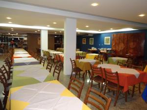 a row of tables and chairs in a restaurant at Alagoinhas Plaza Hotel in Alagoinhas
