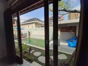 a window view of a pool from a house at Adioga Villa in Ubud +3 photos
