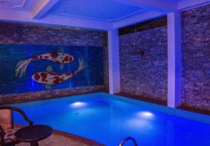 a swimming pool in a house with a fish tank at DK's Backpacker Hotel in Hoi An