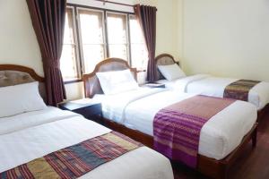 Postel nebo postele na pokoji v ubytování Punyin Hotel Inthanon -ปั้นหยิ่น โฮเทล
