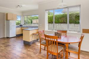 uma cozinha e sala de jantar com mesa e cadeiras em Raumati Sands Resort em Paraparaumu Beach