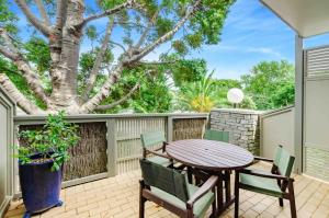 d'une terrasse avec une table, des chaises et un arbre. dans l'établissement Raumati Sands Resort, à Paraparaumu Beach