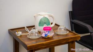 a table with a tea kettle and glasses on it at Woodsy Villa in Sigiriya