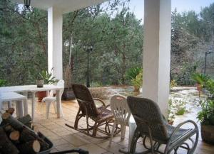 um pátio com 4 cadeiras, uma mesa e uma mesa em Villa Mado em Ceglie Messapica