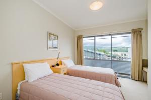 um quarto de hotel com duas camas e uma janela em Raumati Sands Resort em Paraparaumu Beach