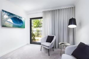 a living room with a chair and a window at Lamour Holiday Beach House in Gold Coast