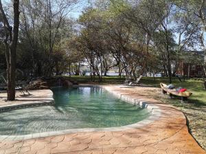 a pool of water with a bench in a park at Mama Out of Africa in Livingstone