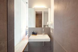 ein Badezimmer mit einem weißen Waschbecken und einem Spiegel in der Unterkunft Hotel & Restaurant Zur Glocke in Höchstädt an der Donau